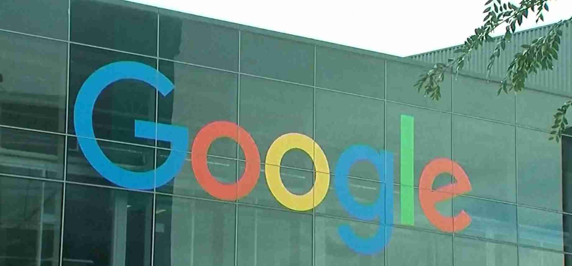 Google logo in colorful letters on a glass-office building exterior.